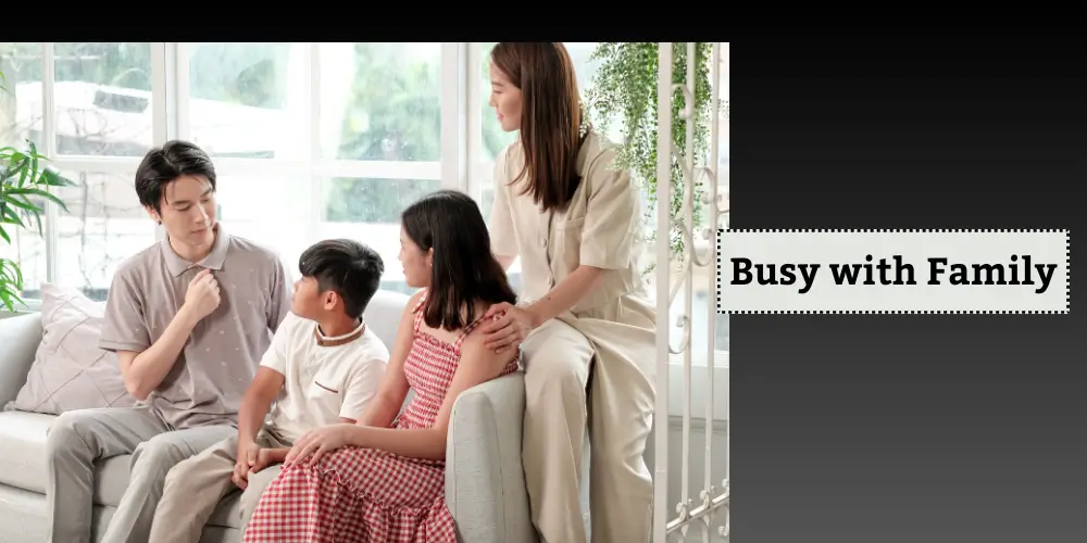 A family of four sits together on a sofa, engaged in conversation and spending quality time