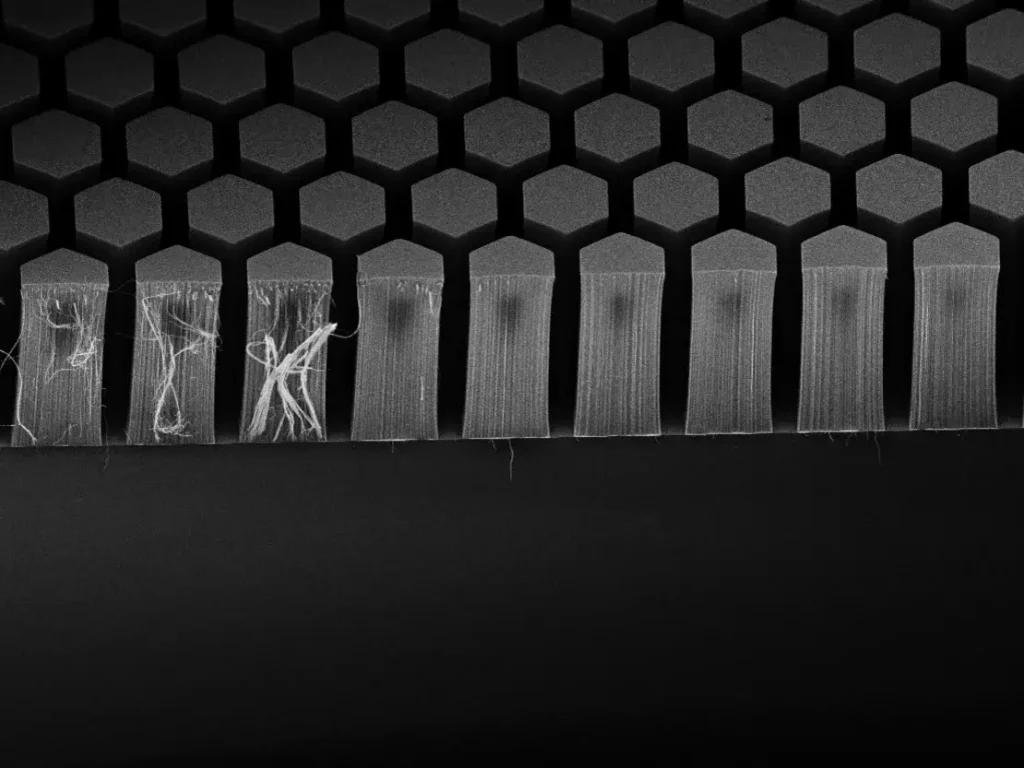 A microscopic close-up of Vantablack nanotube structure, showcasing hexagonal patterns and light-absorbing vertical nanotubes.