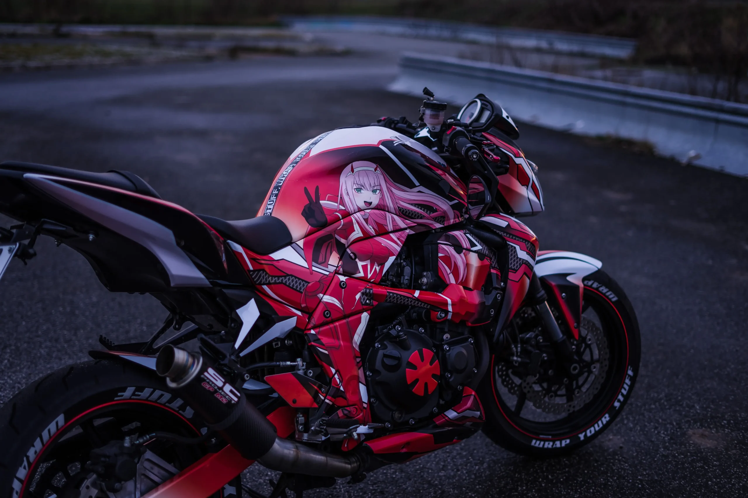 Red anime-themed motorcycle wrap featuring a vibrant character design and custom accents