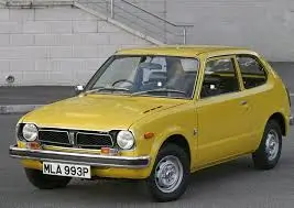 First-generation Honda Civic, a compact yellow hatchback from the 1970s with a vintage design.